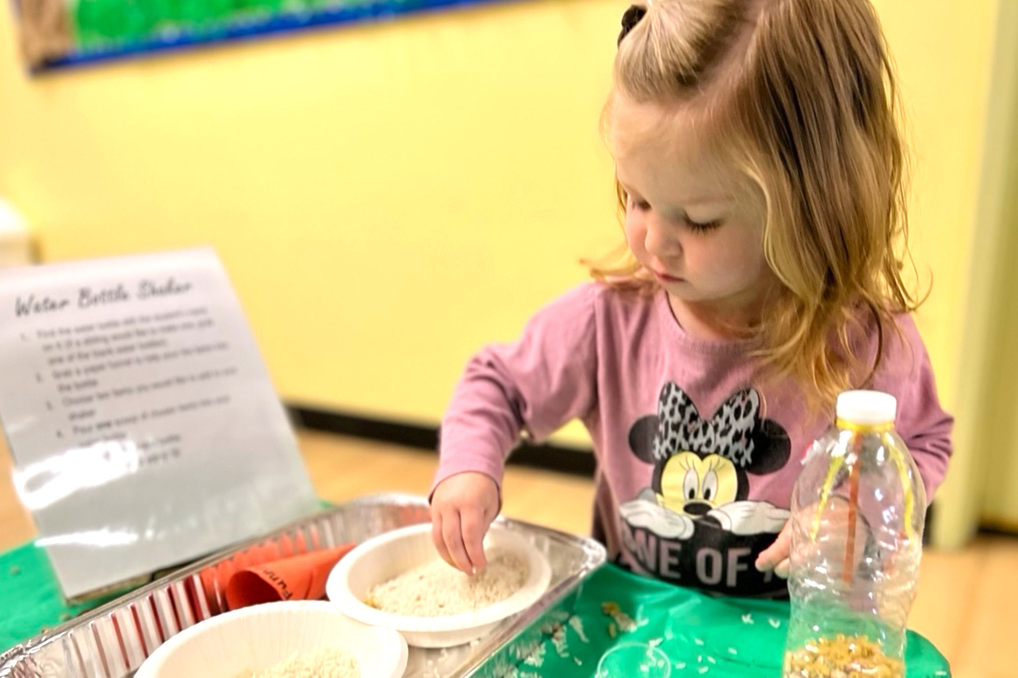 Smiling toddler in Village Preschool playing with building blocks